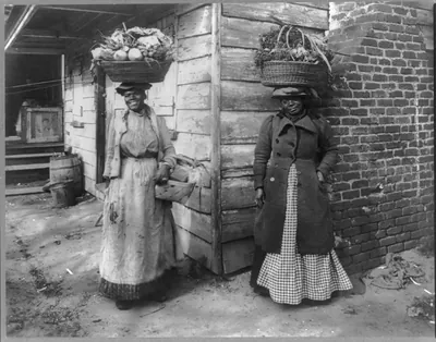 [South Carolina. Charleston. African American women carrying baskets of vegetables on their heads]