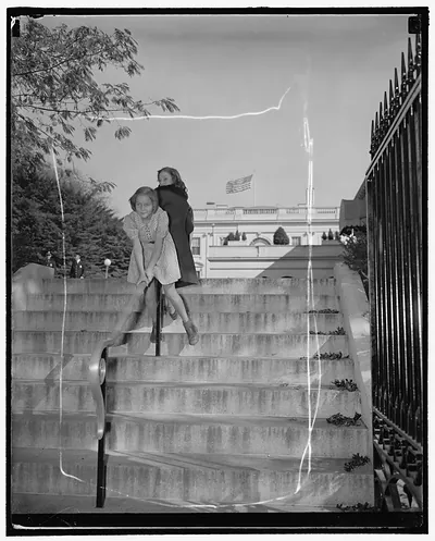 This is a very important picture. Washington, D.C., Oct. 27. A photographer was covering the White House yesterday, snapping pictures of important men after they had conferred with President Roosevelt on his way back to the laboratory he happened to notice thse two little girls, Patricia Freeman and Frances Gross, having fun sliding on the new railing that leads up to the executive offices. Anythi