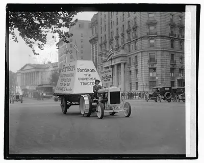 Fordson tractor in parade with Universal Tractor banner