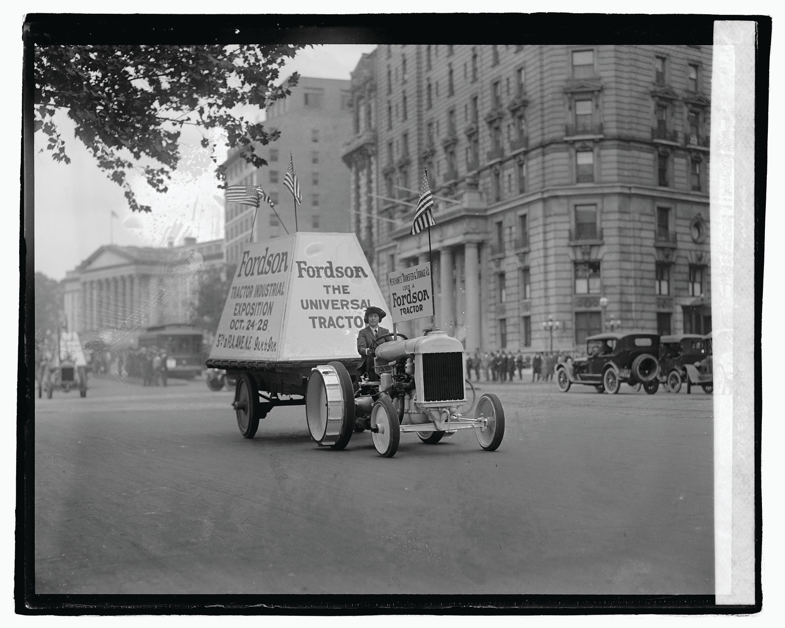 Fordson tractor in parade with Universal Tractor banner — historic image