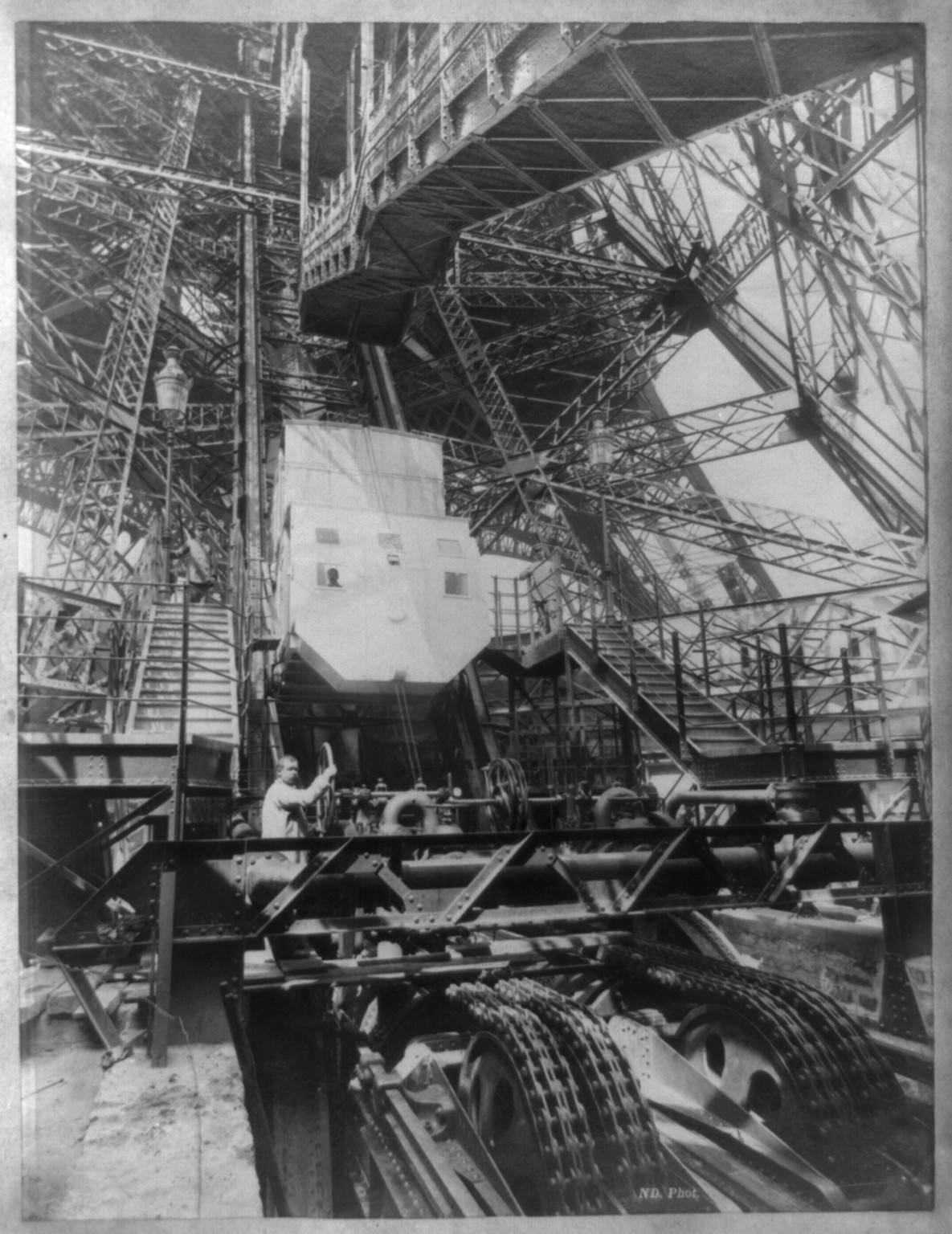 [Eiffel Tower machinery with man beside wheel that raises elevator(?), during Paris Exposition] / ND phot., [between 1887 and 1889?] — historic photograph