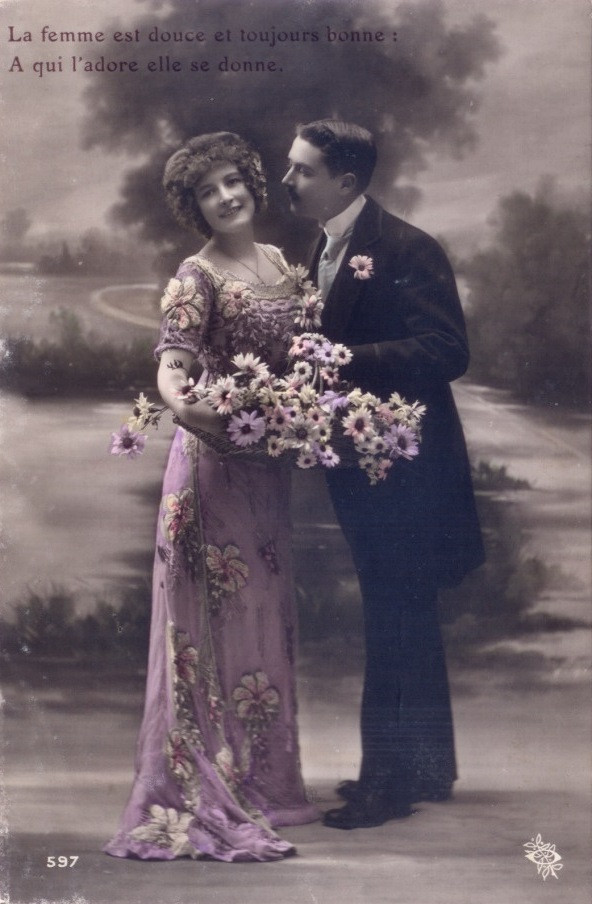 Hand-colored postcard of a couple with flowers and French verse — vintage postcard