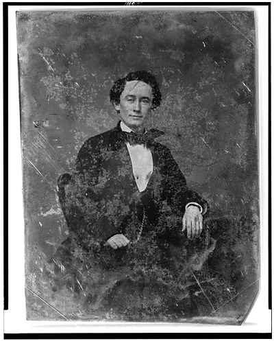 Seated man in dark suit and bow tie, half-length portrait