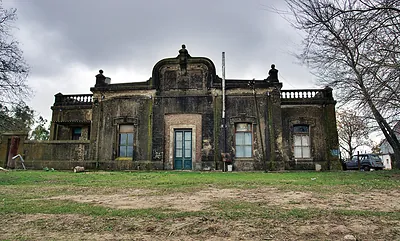 Weathered historic mansion with balustrade and ornate pediment