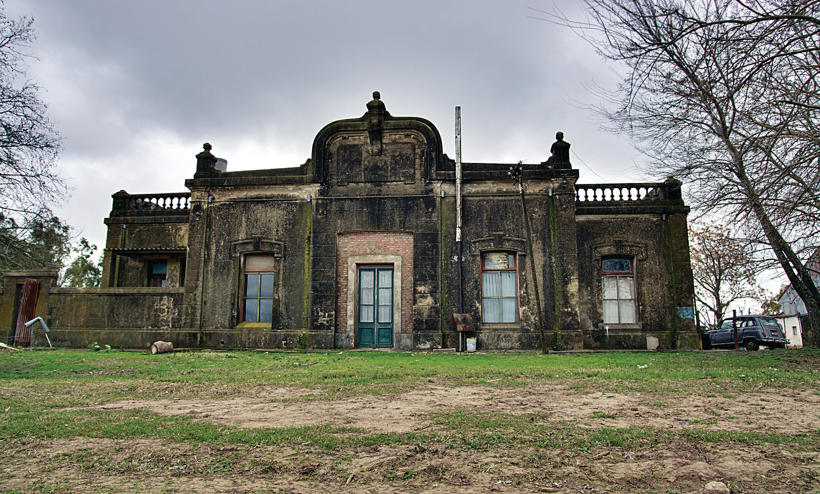 Weathered historic mansion with balustrade and ornate pediment — historic image
