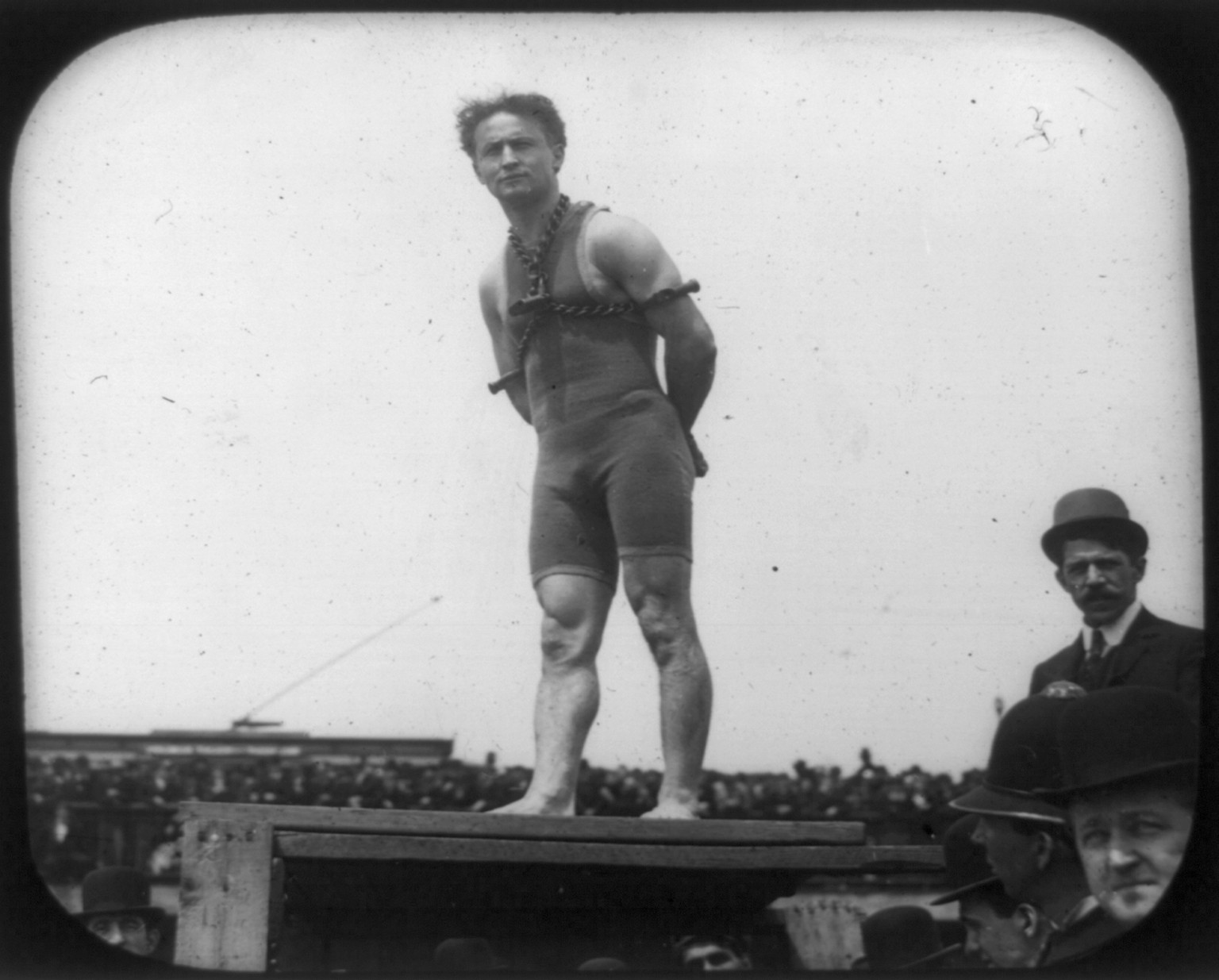 [Harry Houdini in bathing suit and chains on platform in front of crowd], [ca. 1906?] — historic print