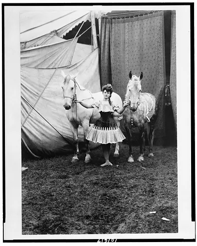 [Bareback rider standing between two horses outside circus tent]