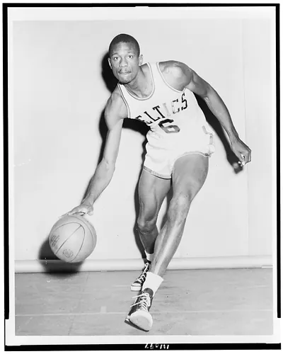 [Bill Russell, full-length, facing front, wearing Boston Celtics uniform, dribbling basketball]