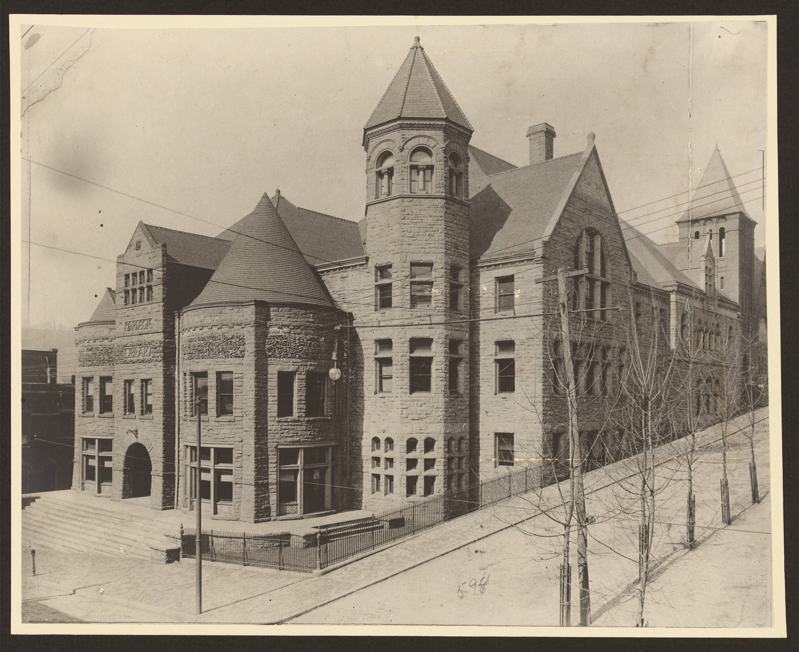 Stone civic building with turrets and tower, street view — historic image