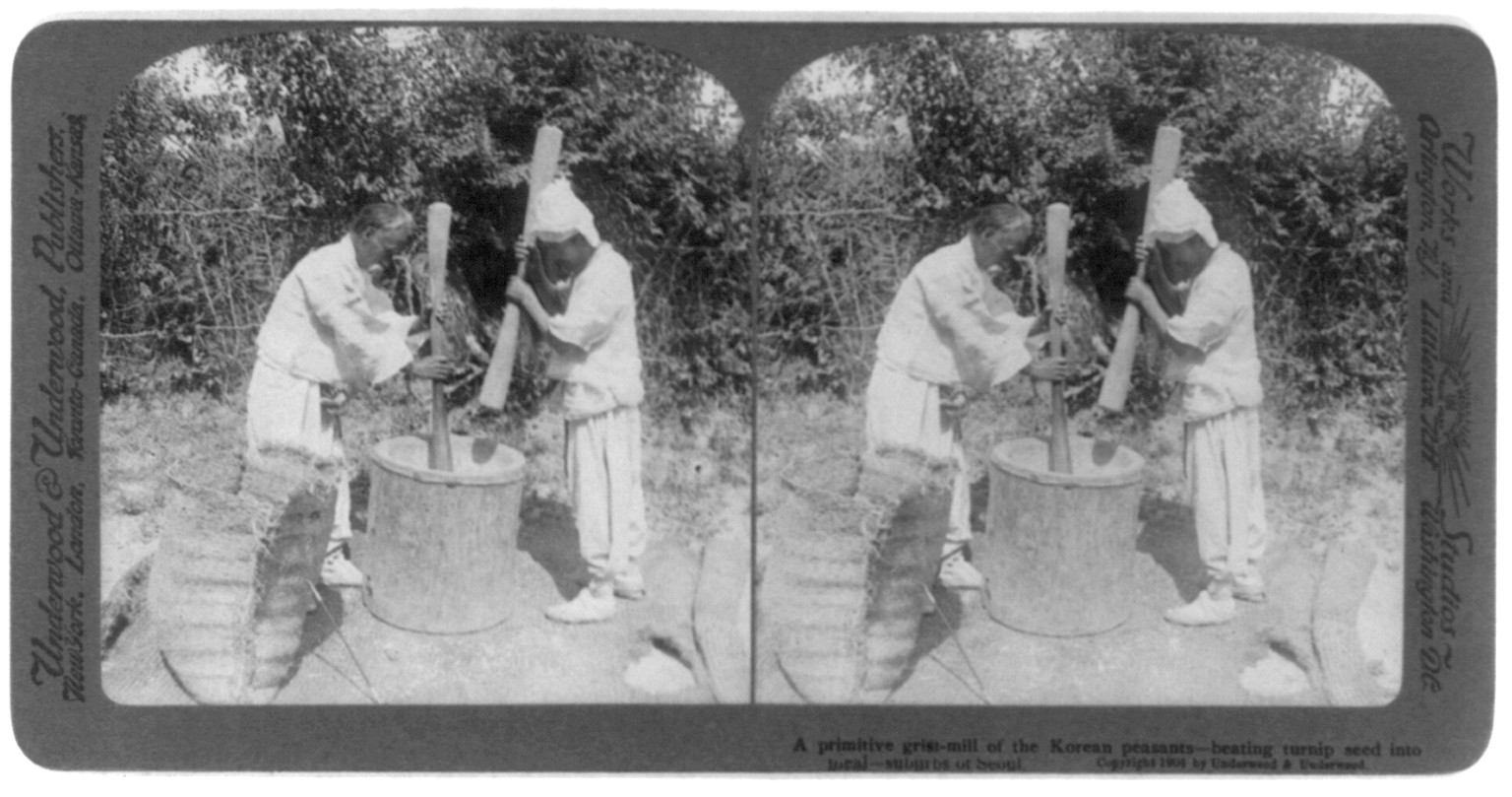 Seoul, Korea: A primitive grist-mill of the Korean peasants - beating turnip seed into meal, c1904. — historic photograph