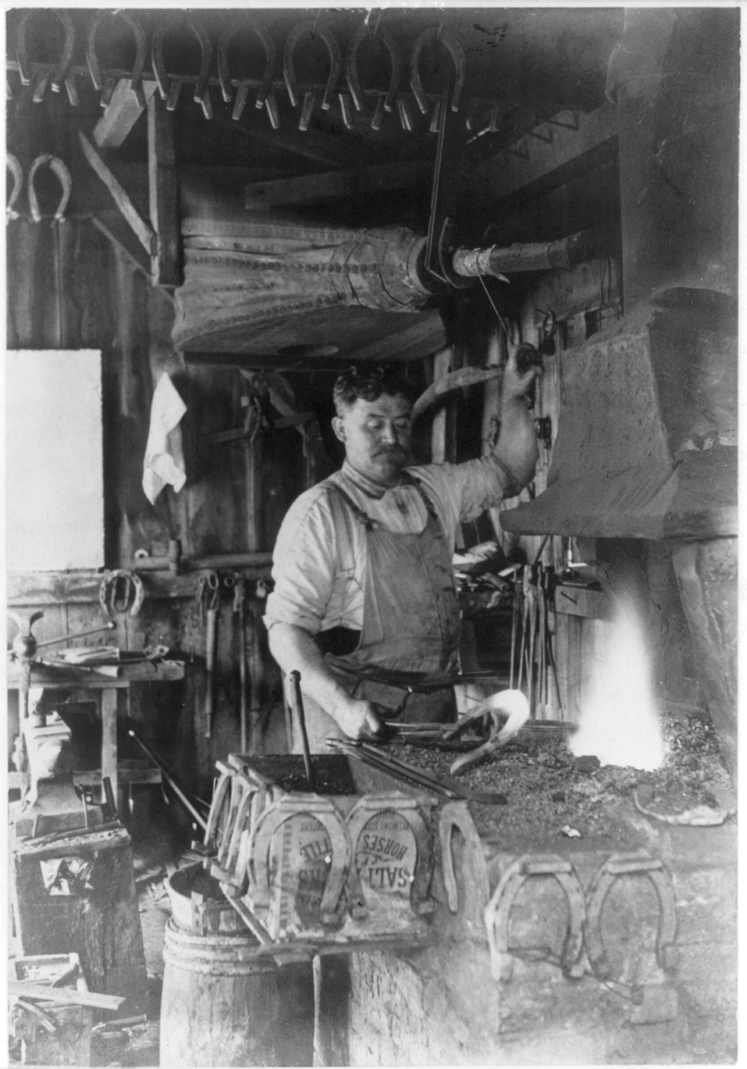 [Blacksmith making a horseshoe] — historic photograph