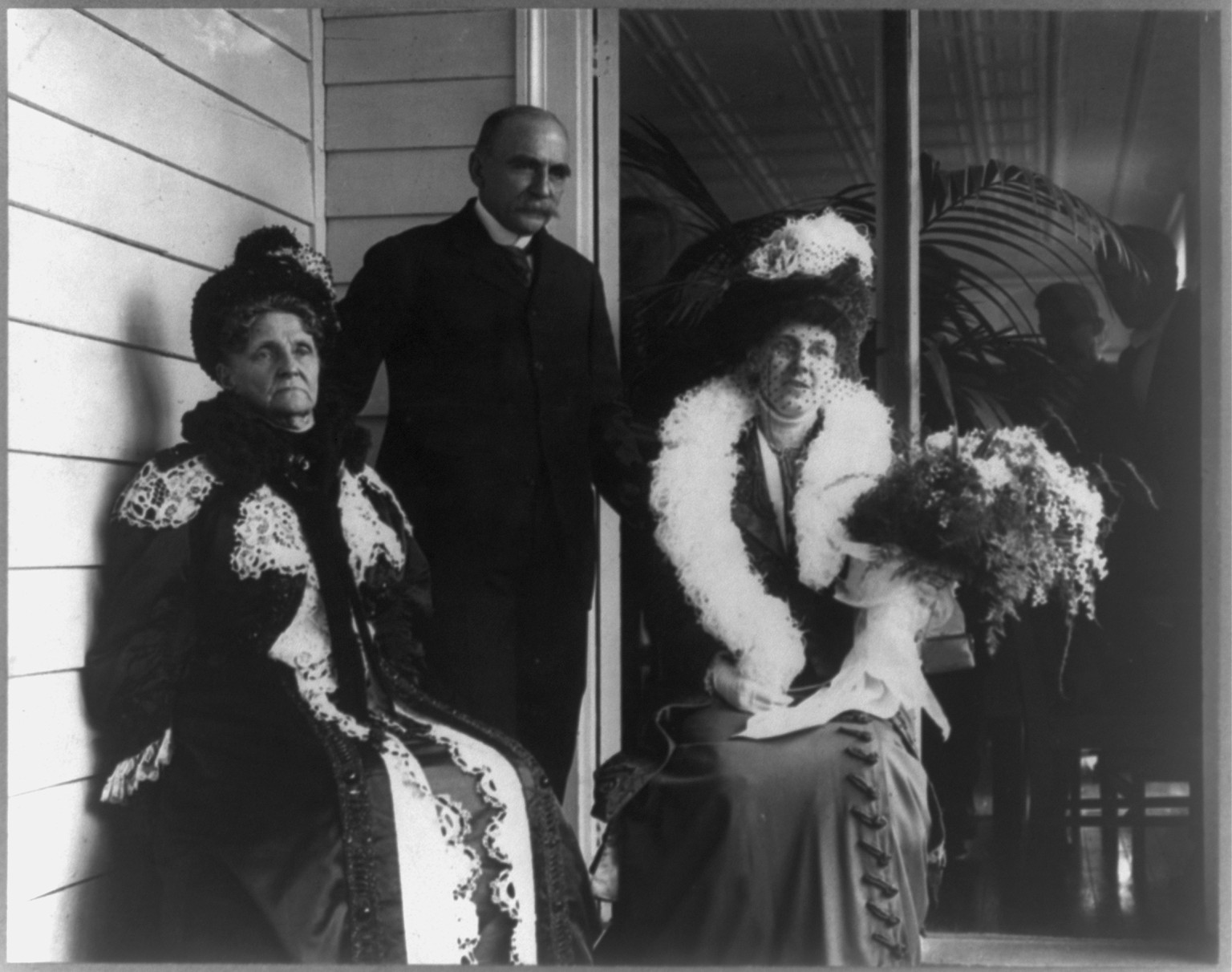 Hetty Howland Robinson Green seated on porch with Mr. and Mrs. M.A. Wilks, c1911. — historic photograph