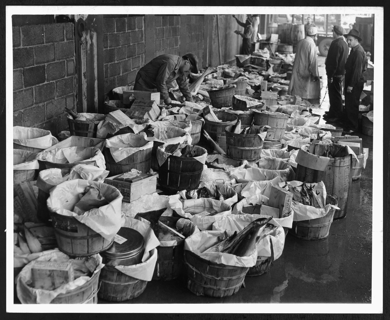 Fish orders packed in baskets at a market — historic image