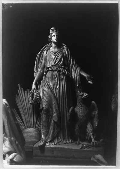 [Sculpture of female figure draped in robe; eagle beside her, clutching arrows in one of its claws. Signature of J. Crawford on base]