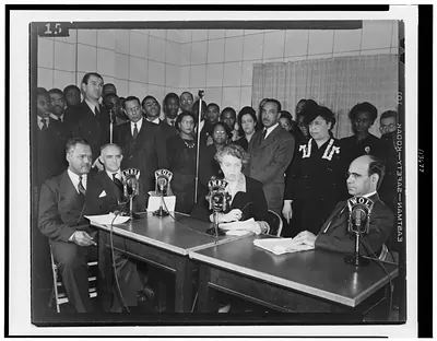 Seated woman at radio microphones during a press conference