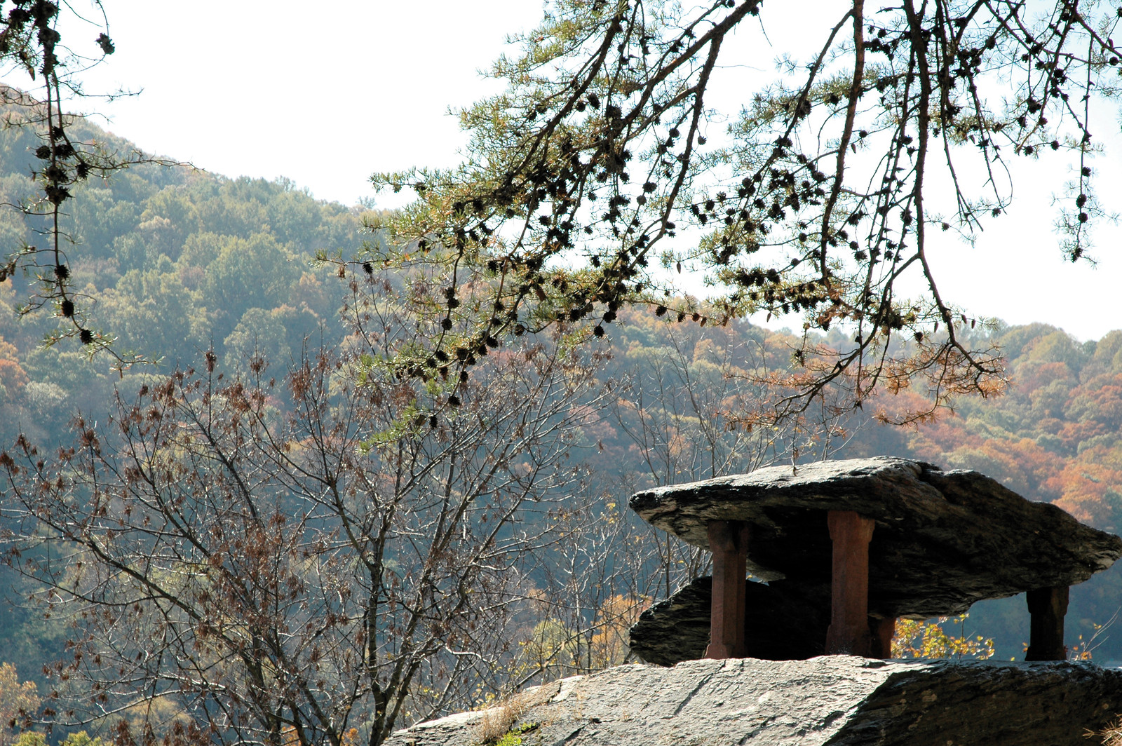 Stone slab shelter on rock above autumn wooded hills — historic image