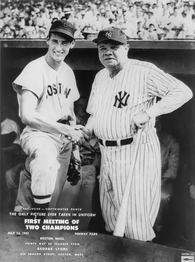[Ted Williams and Babe Ruth shaking hands in dugout of Fenway Park, July 13, 1943]