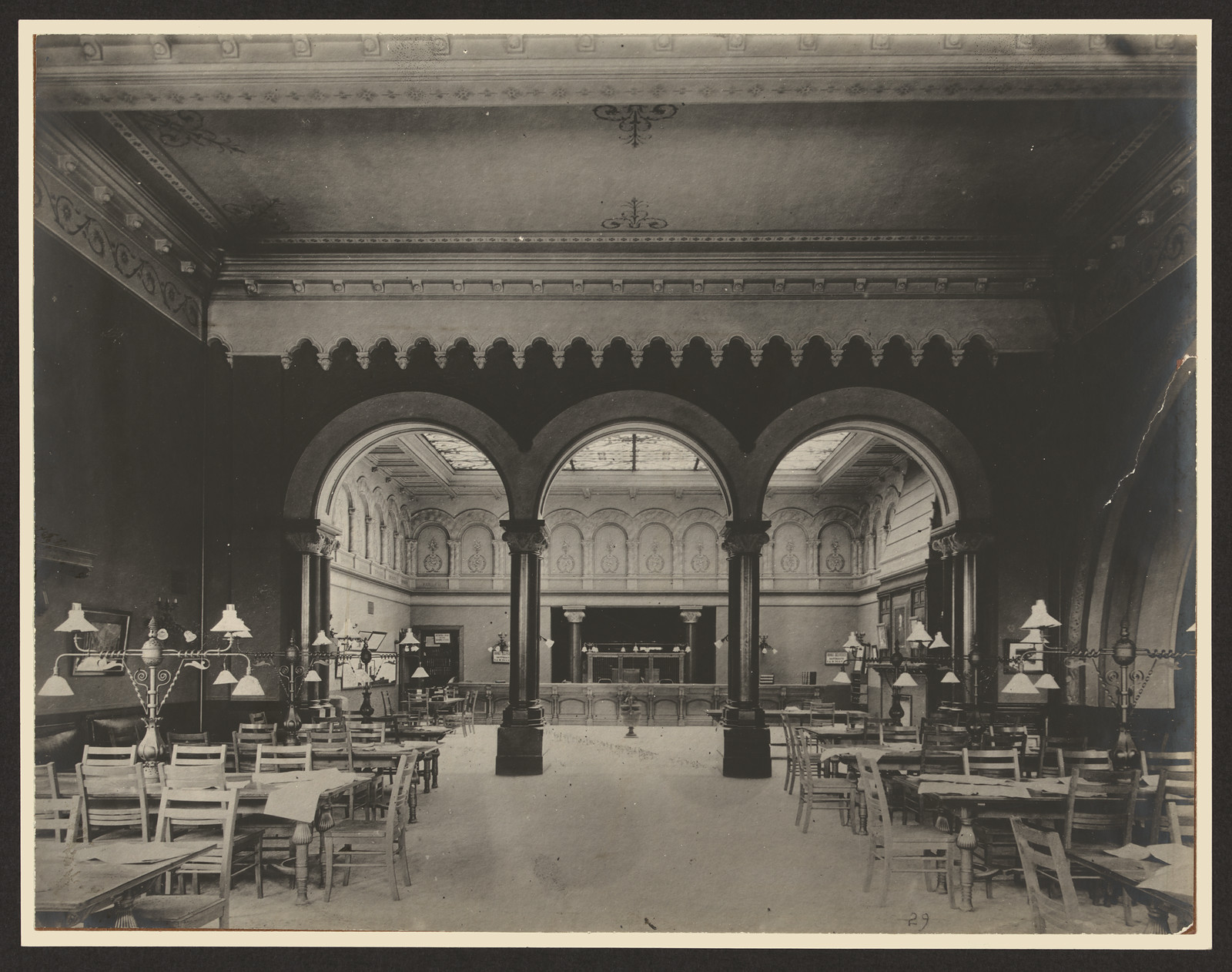 Interior of a reading room with arches and tables — historic image