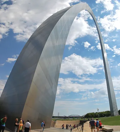 Gateway Arch rising above visitors and riverfront grounds