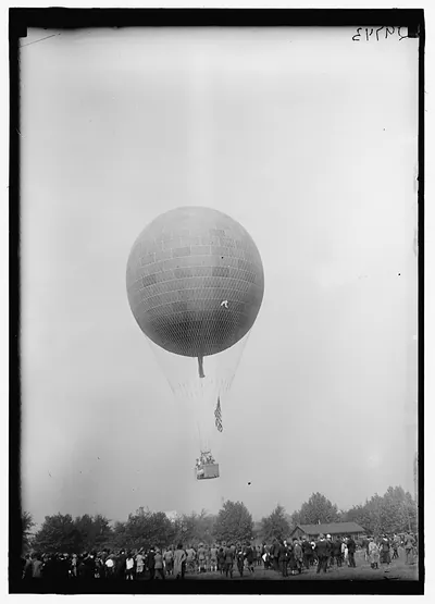 Large balloon ascension with crowd watching on open field