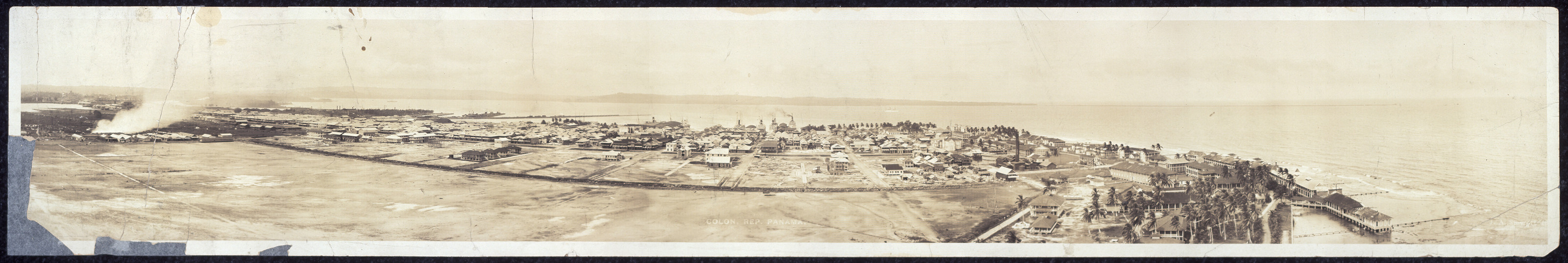 Panoramic view of a coastal town along a bay — historic image