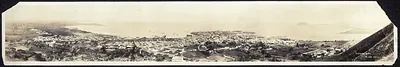 Panoramic sepia photograph of a coastal city from a hill