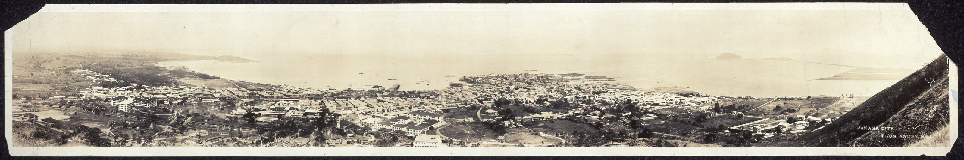 Panoramic sepia photograph of a coastal city from a hill — historic photograph