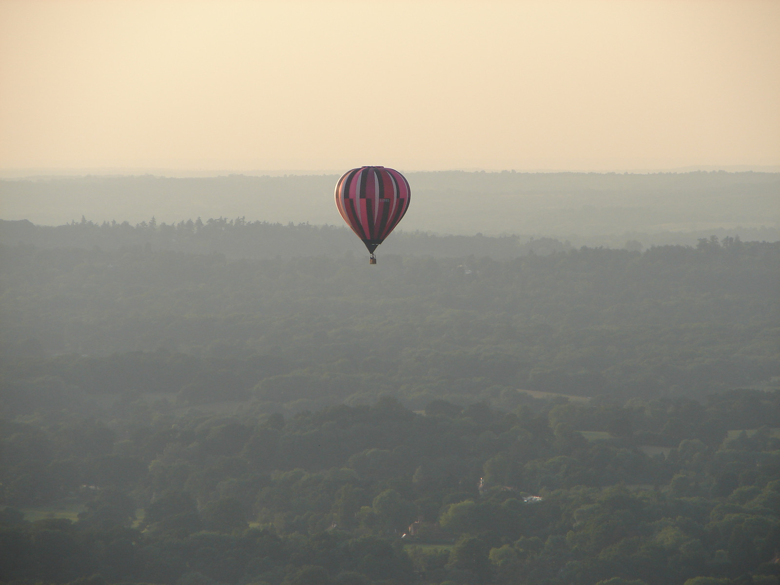 Hot air balloon over hazy countryside at dusk — historic image