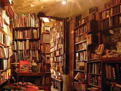 Crowded old bookshop interior with tall shelves