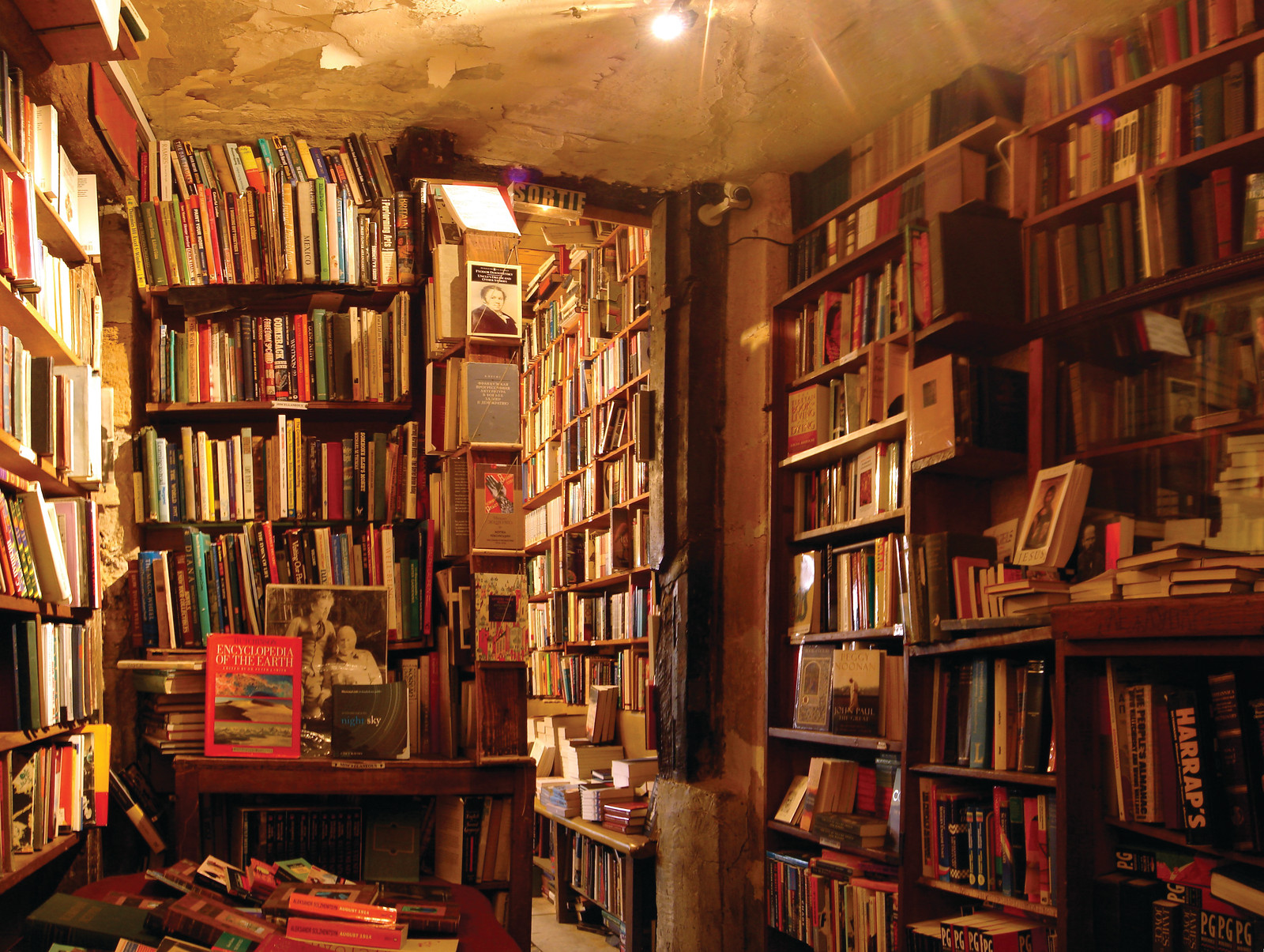 Crowded old bookshop interior with tall shelves — historic image
