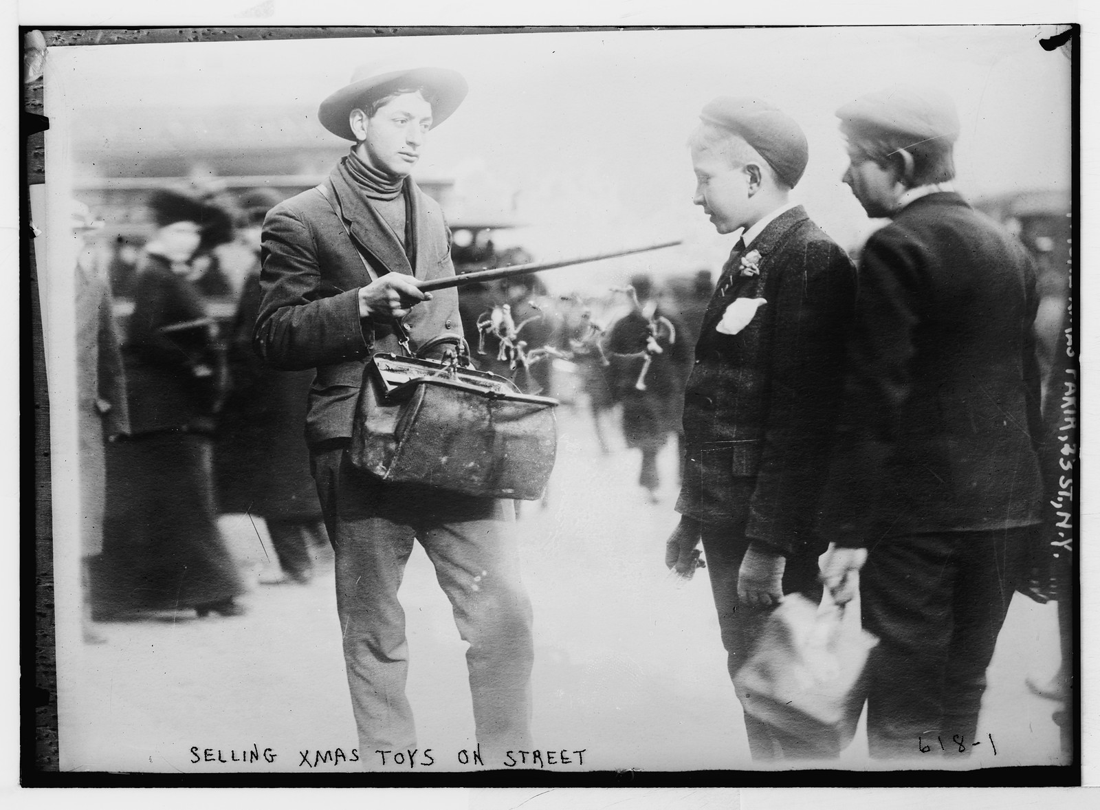Street vendor showing Christmas toys to boys 23rd., St. New York, 12/7/08. — historic photograph