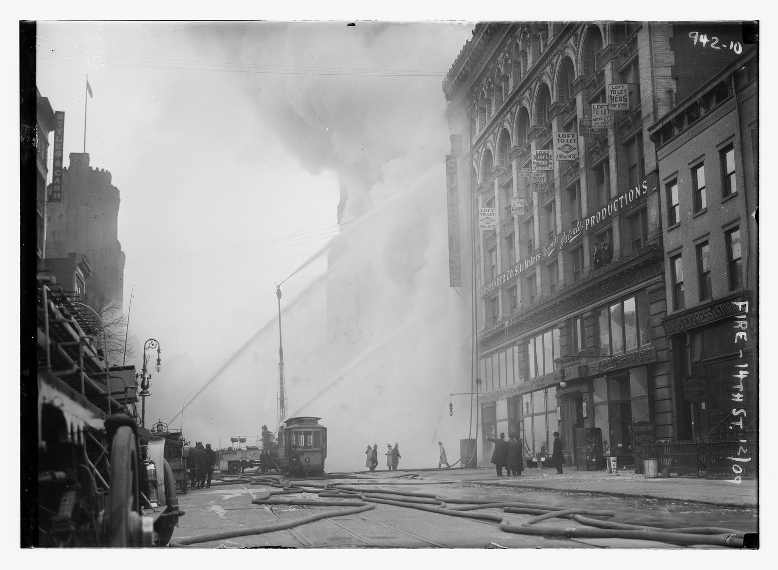 Firemen spraying burning building on 14th St., trolley in foreground, New York, 12/20/09. — historic photograph