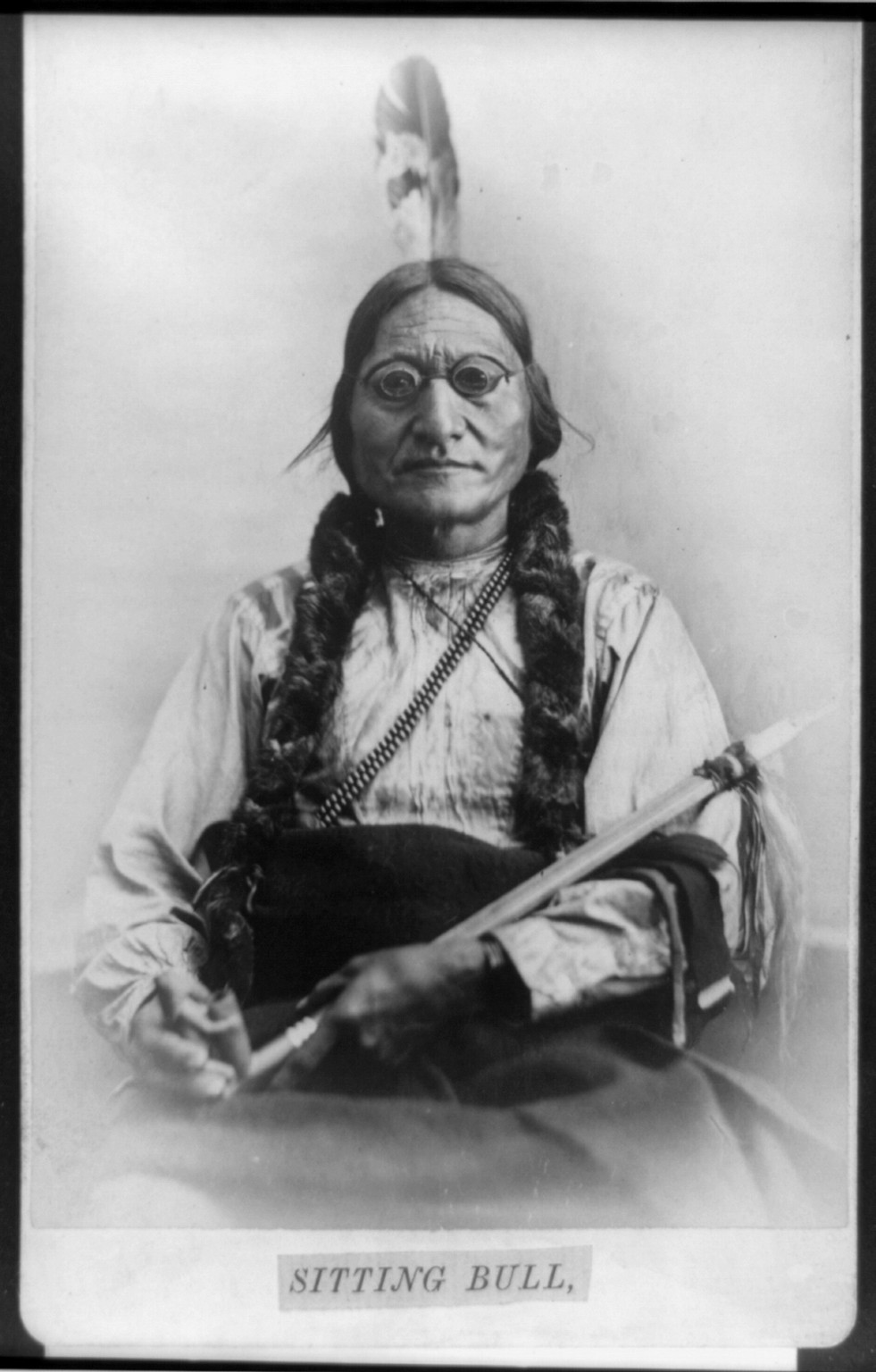 [Sitting Bull, half-length portrait, seated, facing front, holding calumet], c1881. — historic photograph