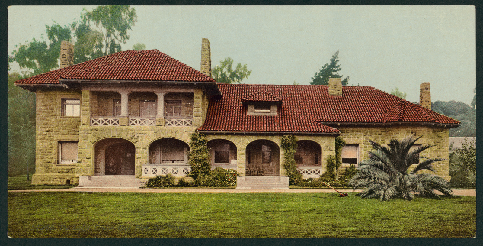 Stone lodge with red tile roof and arched porches — historic image