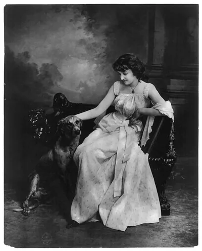 [Young woman modeling: Full lgth., seated with dog]