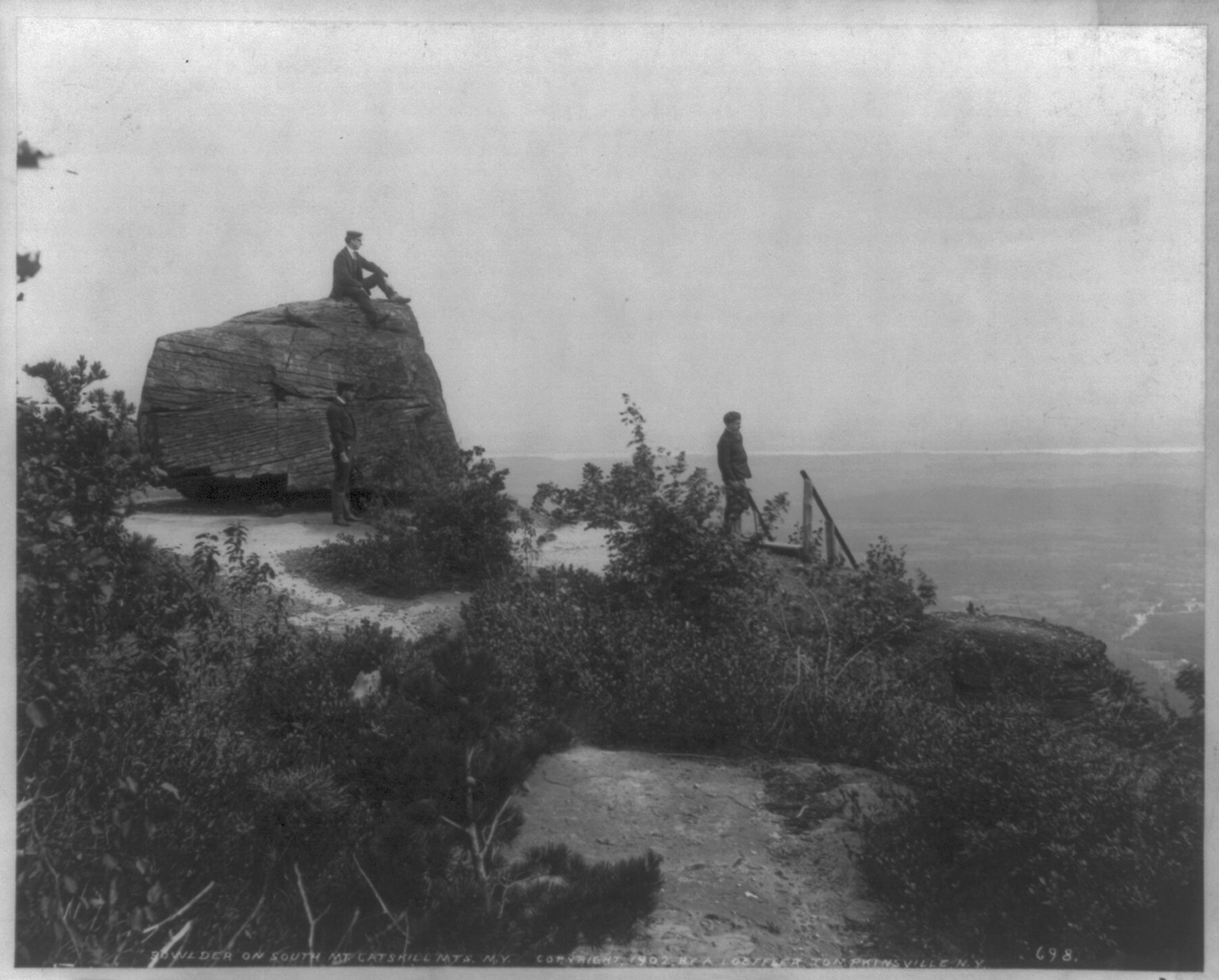 [Men seated on rocks overlooking Catskill Mountains: Sunset Rock, Kaaterskill Cove], c1905. — historic photograph