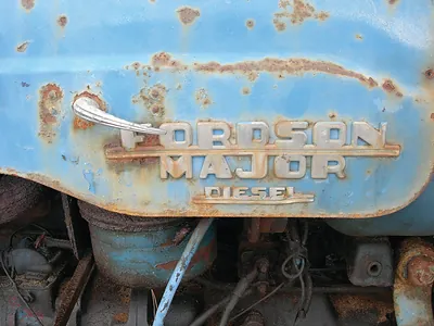Rusty blue Fordson Major Diesel tractor badge close-up