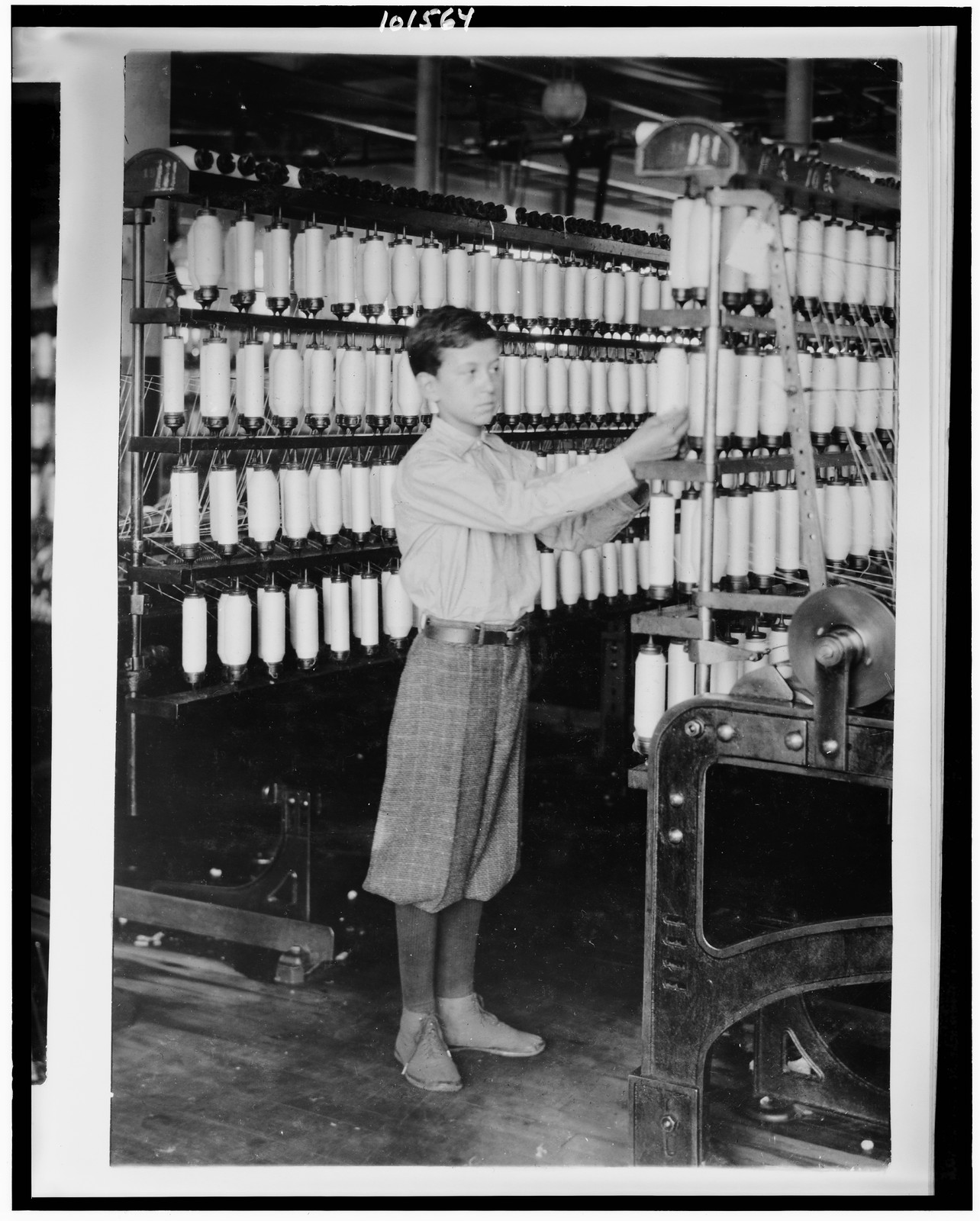 [Back boy - 14 years old - Mule room. Berkshire Cotton Mills.] Location: Adams, Massachusetts. / Lewis W. Hine., 1916 July 10. — historic photograph