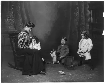 [Woman and 2 girls crying over dead bird; boy holding cat by scruff of neck]