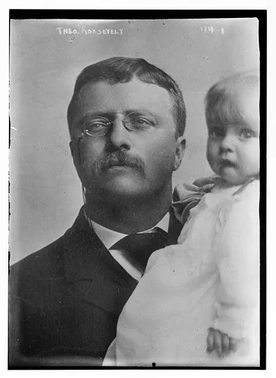 Theodore Roosevelt, holding child
