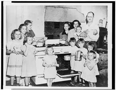 [Mr. and Mrs. Lloyd Brooks of Pittsfield, Maine, and their twelve daughters posed around stove in kitchen]