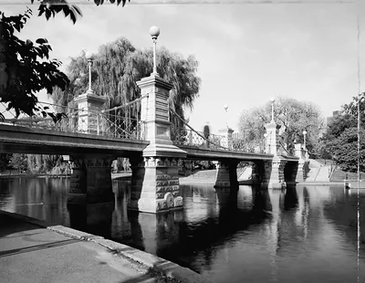 Stone bridge over a pond with weeping willows