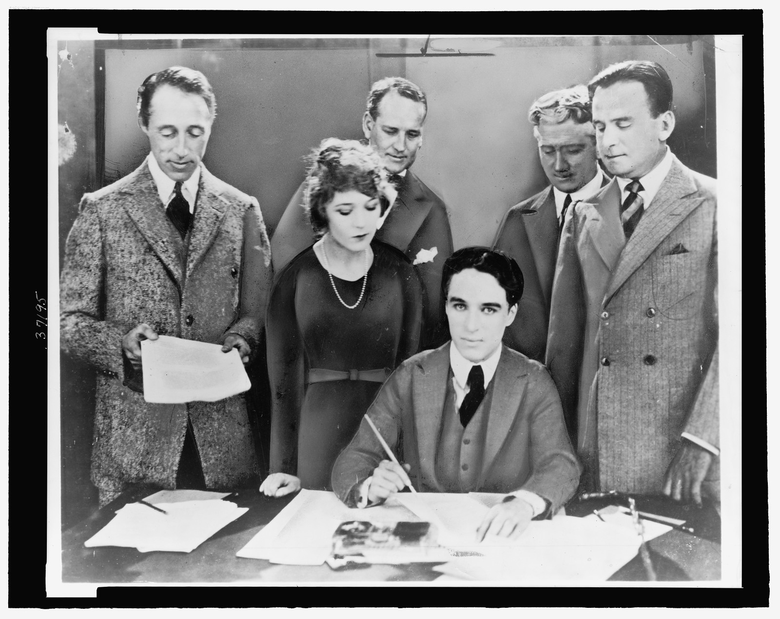 [D.W. Griffith, Mary Pickford, Charlie Chaplin (seated) and Douglas Fairbanks at the signing of the contract establishing United Artists motion picture studio], 1919, printed 1959? — historic photograph