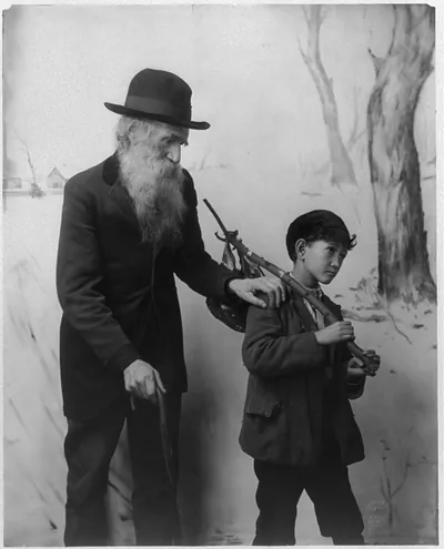 [Old bearded man with hand on the Asian boy's shoulder]