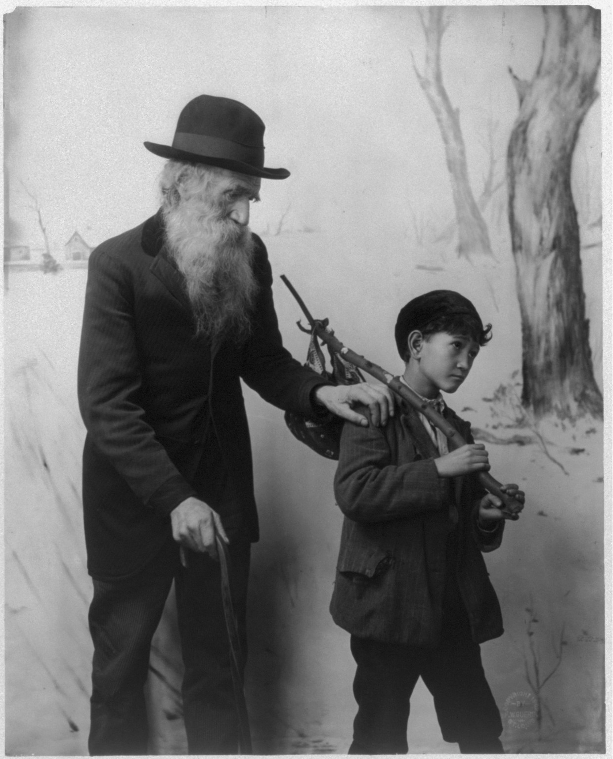[Old bearded man with hand on the Asian boy's shoulder], c1902. — historic photograph