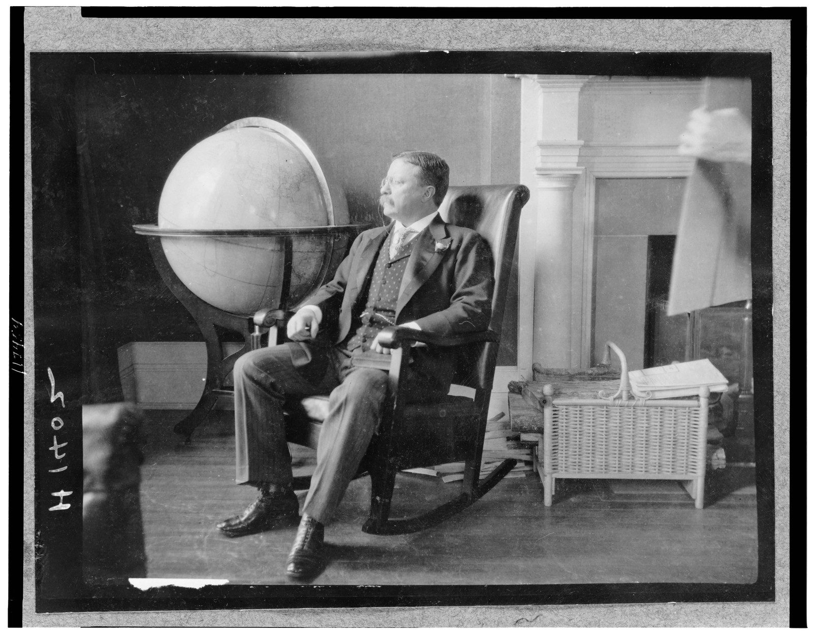 [Theodore Roosevelt, full-length portrait, seated in rocking chair, facing left, by large globe], [1908(?)] — historic photograph
