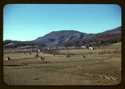 Hay stacks and farm fields in a mountain valley