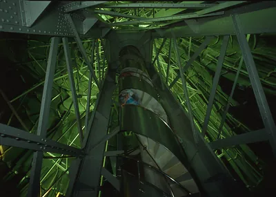 Green-lit steel interior with spiral staircase around central column