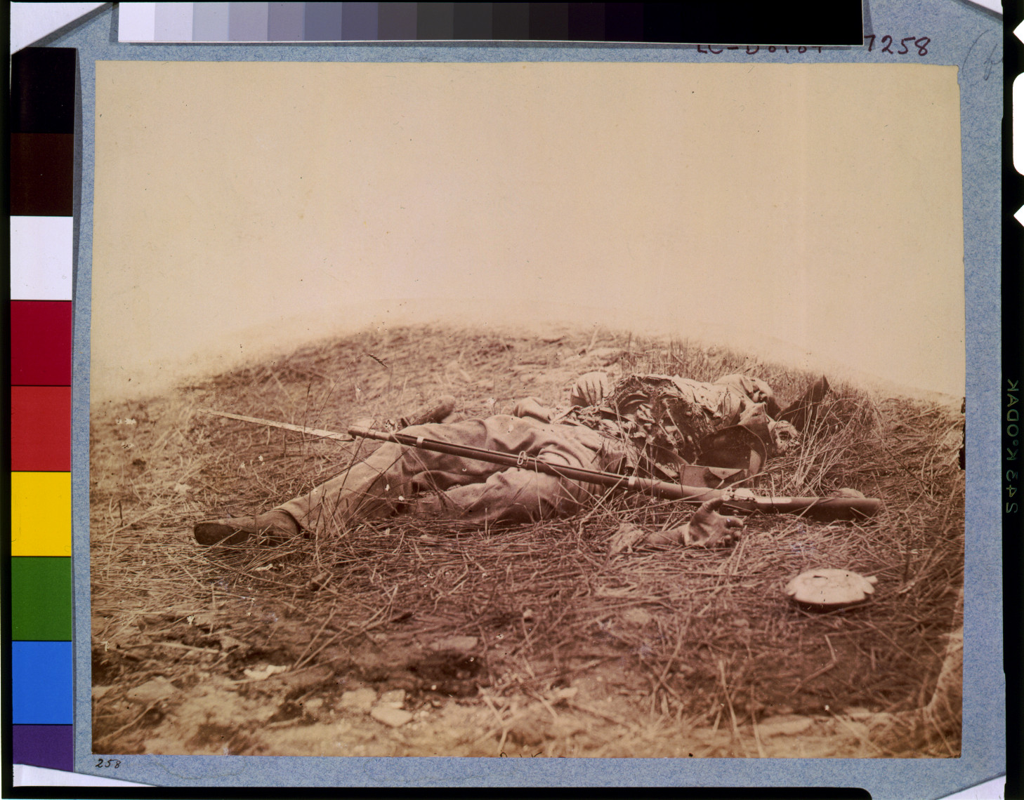 Dead Civil War soldier with rifle on a battlefield hillside — historic image