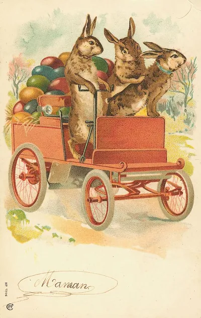 Rabbits driving a red car loaded with Easter eggs